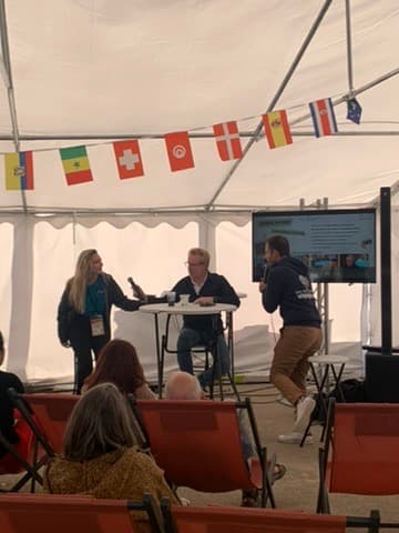 Conférence sous tente — What A Trip, écran et drapeaux